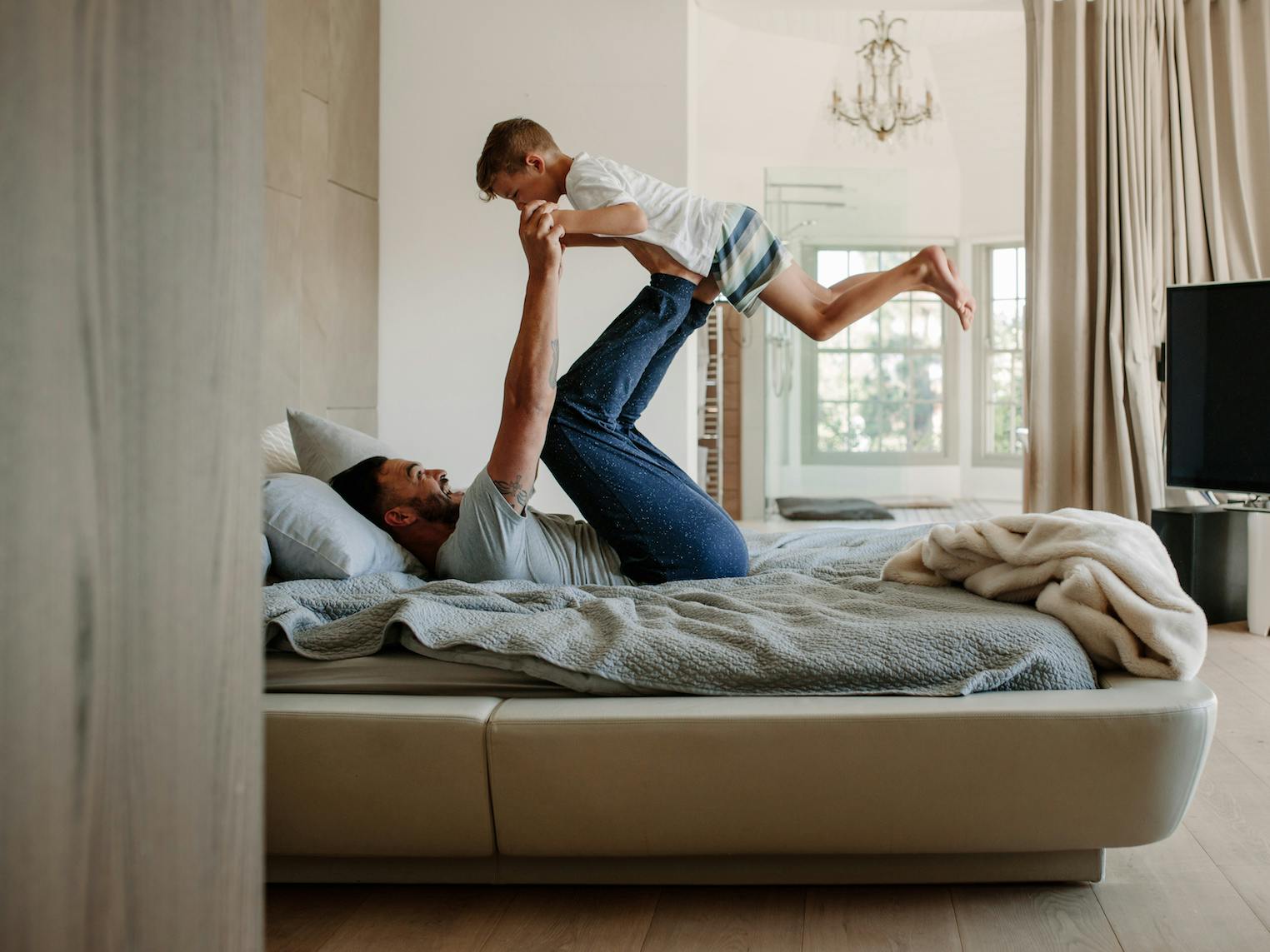 Father raising child in the bed.